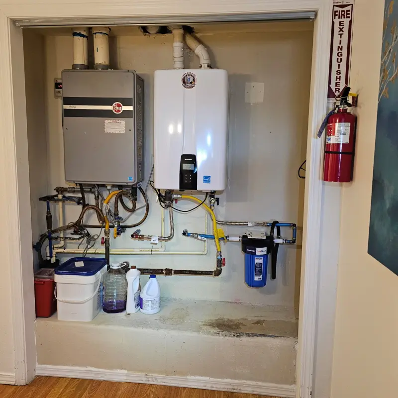 Closet doorway view of a finished tankless replacement, with the new Navien water heater and a sediment filter plumbed in