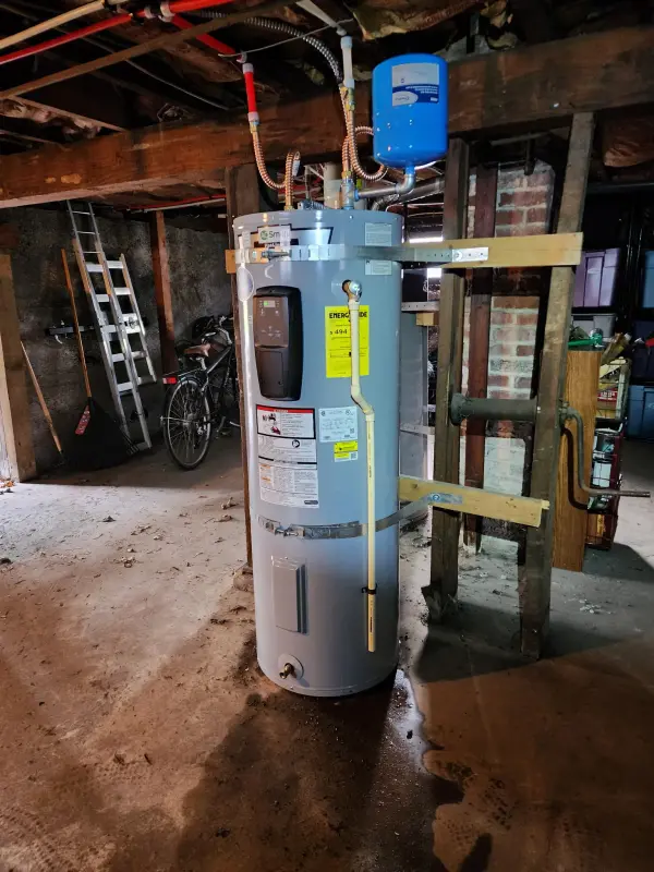 New A.O. Smith electric water heater strapped to fresh blocking in an unfinished basement